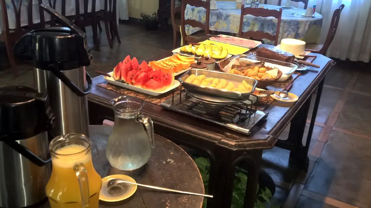 Buffet de café da manhã servido sobre mesa de madeira