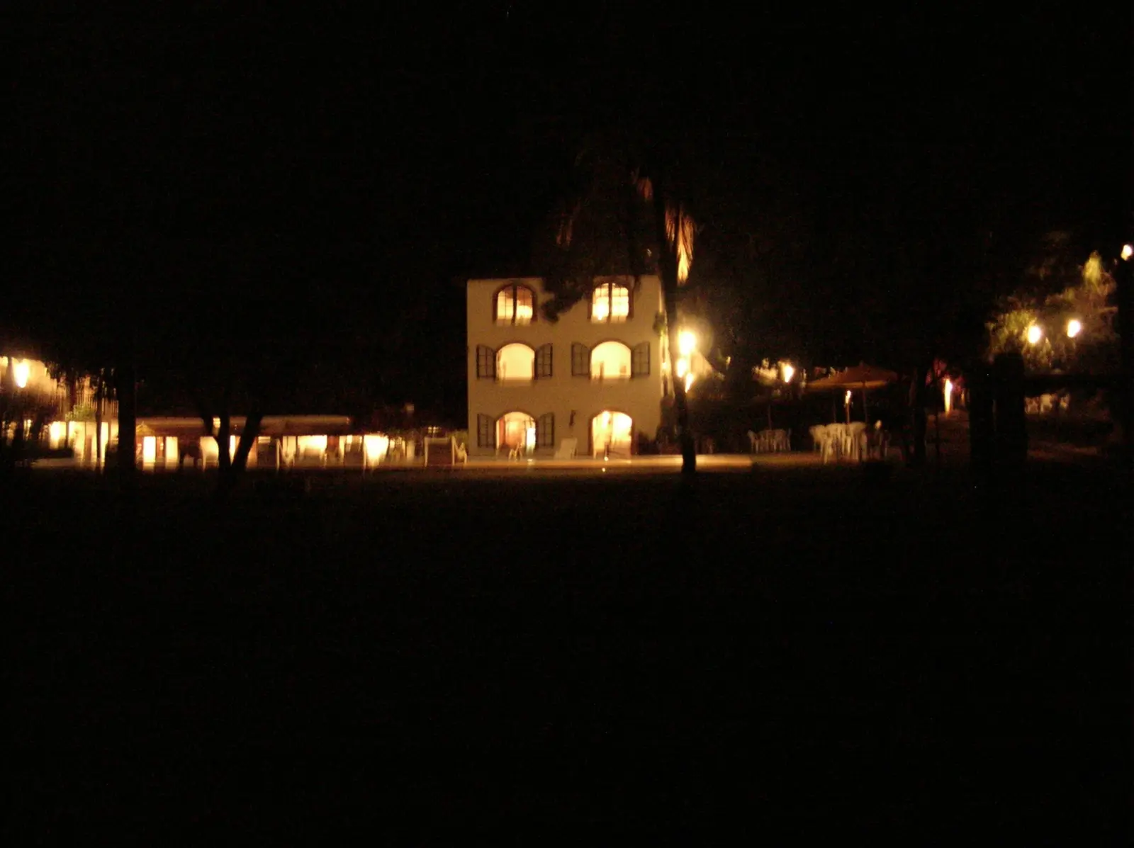 Casarão e piscina iluminados durante a noite