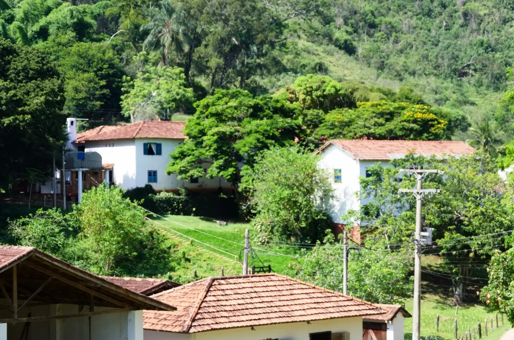 Casario do hotel entre árvores visto da cocheira