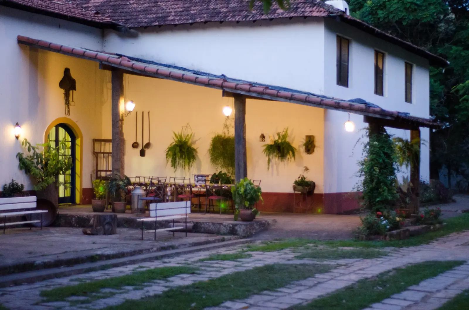 Varanda iluminada da sede da Fazenda Hotel Jatahy ao entardecer